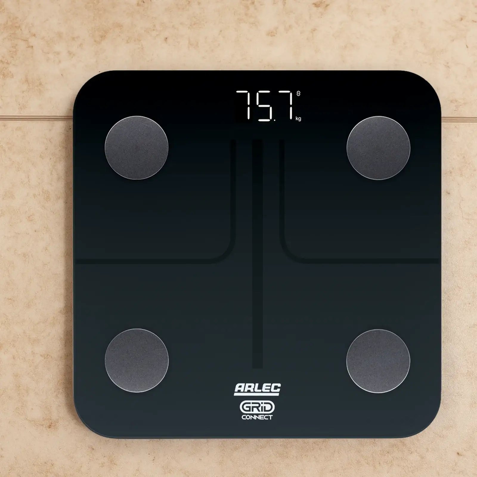 Arlec smart digital bathroom scale on tile floor displaying 75.7 kg weight