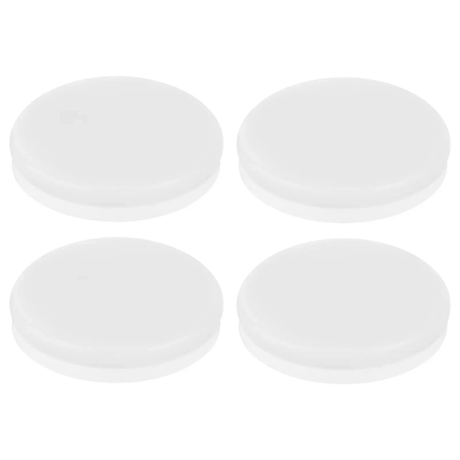 Set of four round white plastic caps on white background
