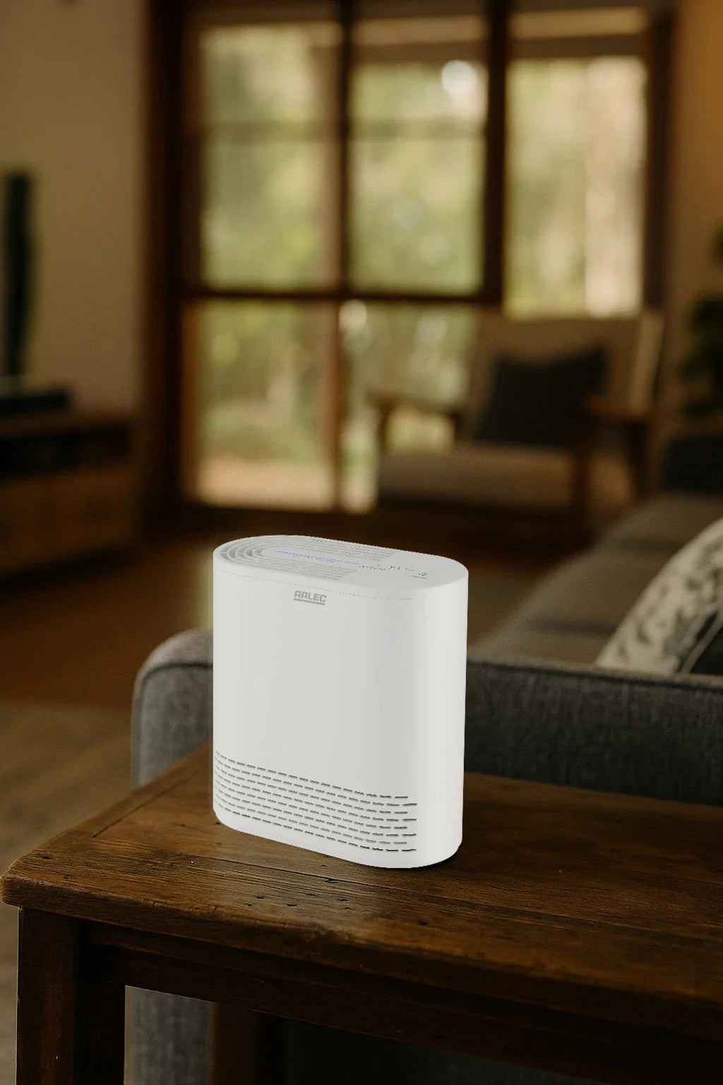 White Arlec air purifier on wooden table in cozy living room with large windows