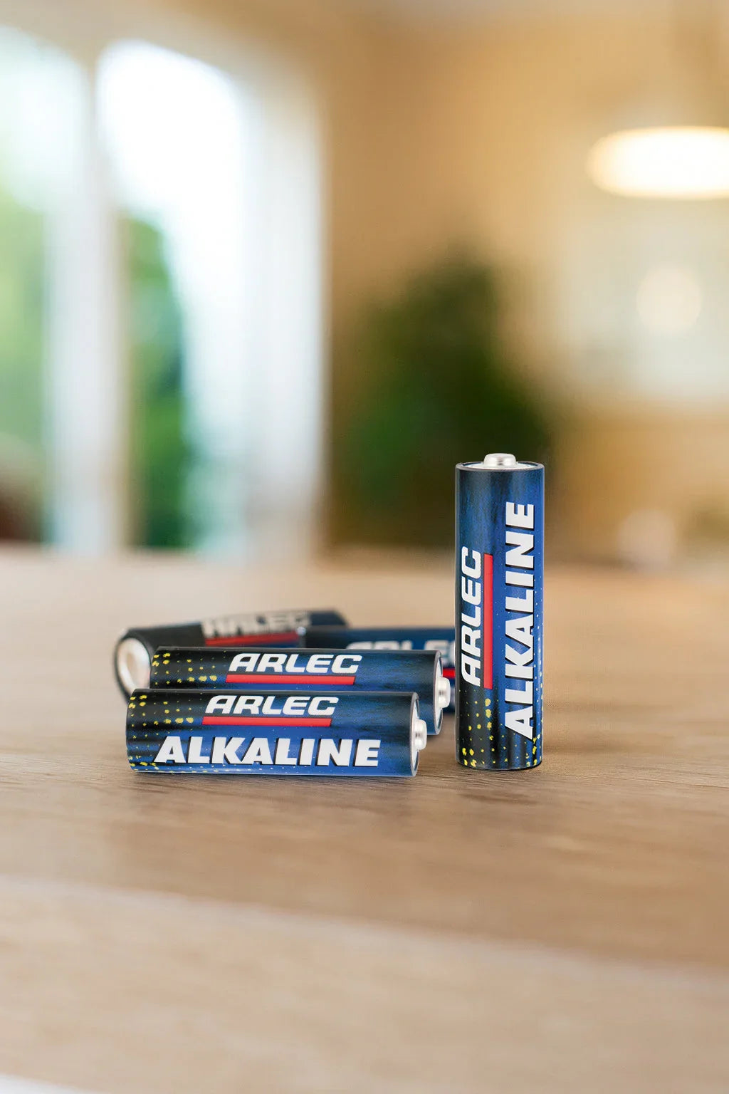 Arlec alkaline AA batteries on a wooden table in a bright indoor setting