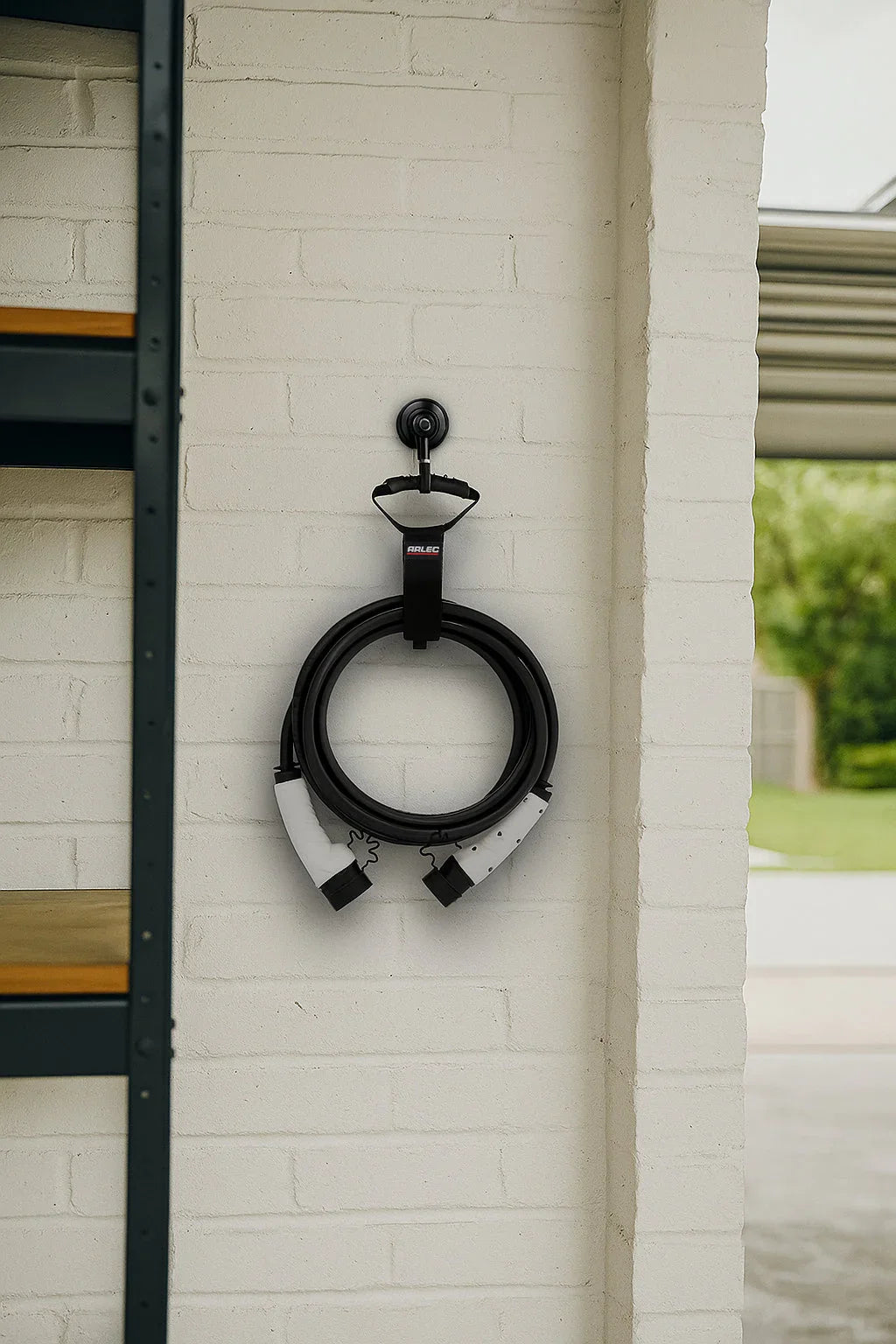 EV charging cable neatly hung on white brick garage wall with Arlec organizer